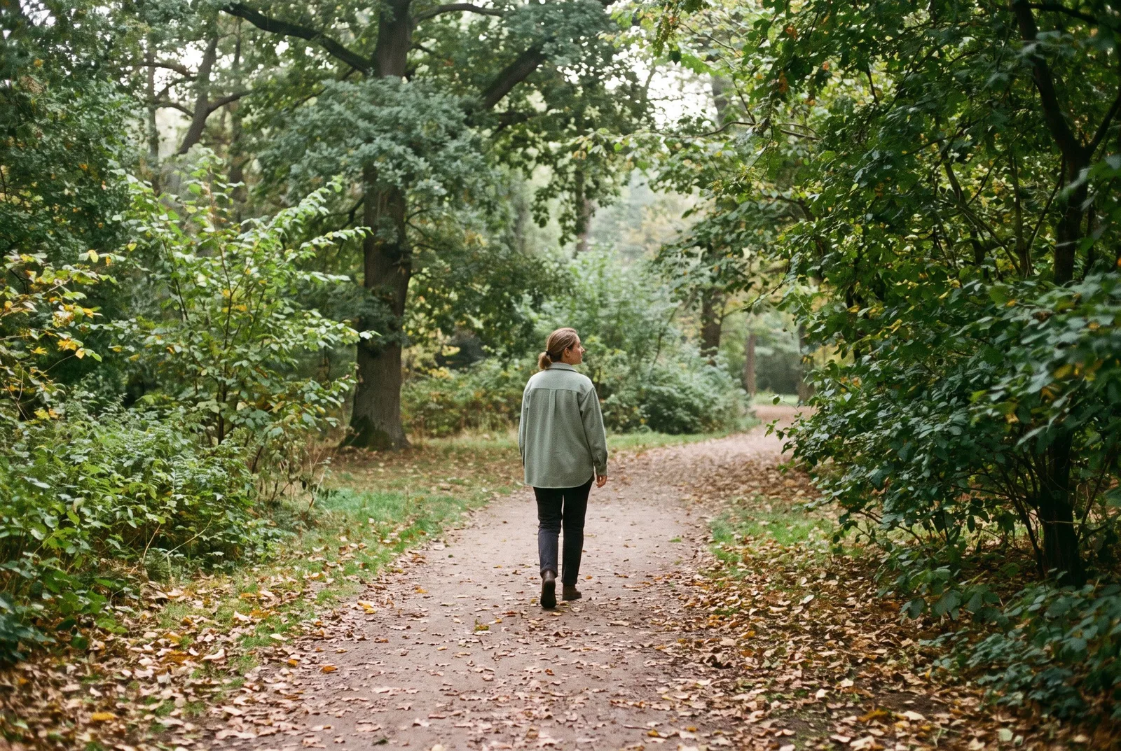 AI-generated scene of a person walking along a quiet, leafy park path.